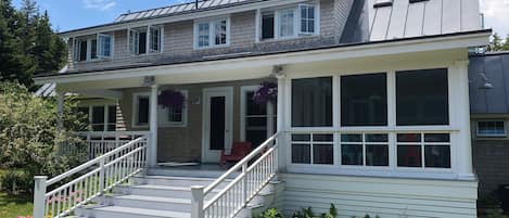 Sweeping back porch over looking swimming pool and woods 