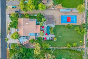 Photo shows entire backyard layout. Pool, Hot Tub, Sports Court, Meadow, House and Guest House.