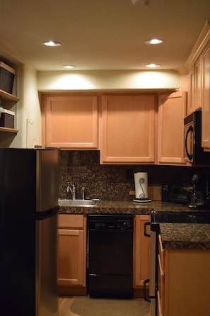 Kitchen with full size refrigerator, microwave, glass top range, and dishwasher.