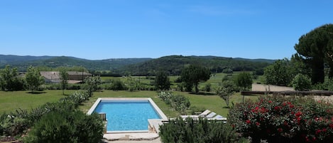 Vue depuis la maison sur le jardin avec piscine