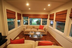 Living room and lake view with lovely sunset light. With upright piano. 