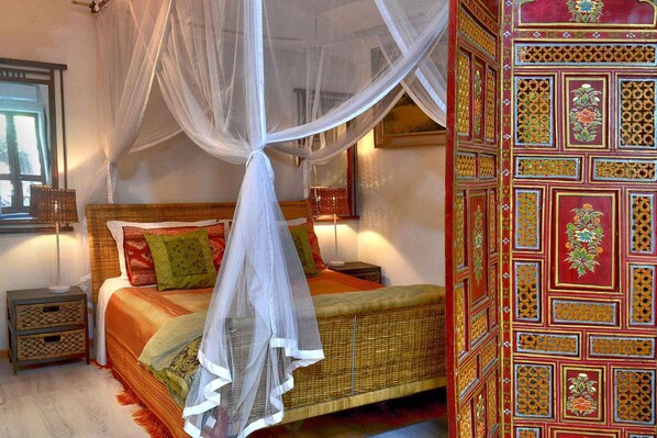 Queen size bed behind privacy screen