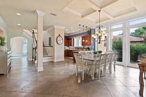 Spacious view of one of the dining tables and gourmet kitchen.