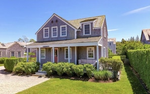 Front yard view of drive and expansive lawn surrounded by privet hedge