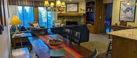 Living room with dining table, wood fireplace, and balcony w/ propane BBQ