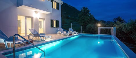 Beautiful night view of the villa and the pool 