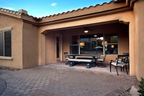 Covered patio with table that seats up to eight with outdoor speakers.