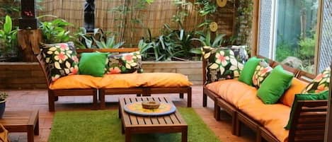 Large undercover entertaining area with bali them sofa, outdoor setting with bar