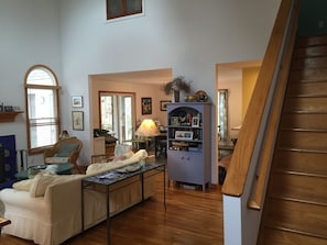 View of living room and stairs. Dining area and door to sun porch in background