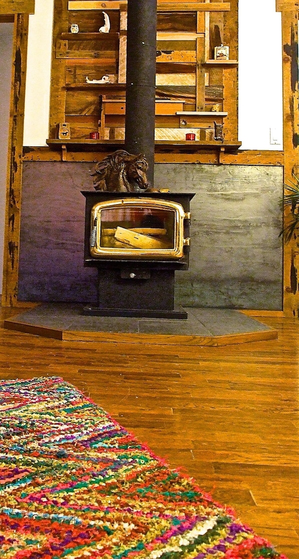 Wood stove features a handcrafted reclaimed wood mosaic. 