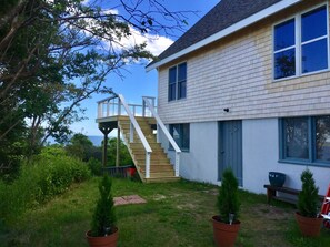 View of entrance to the home and stairs leading to spacious deck.