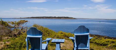Enjoy the view from a pair of adirondack chairs in front of the cottage.