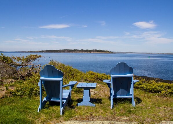 Enjoy the view from a pair of adirondack chairs in front of the cottage.