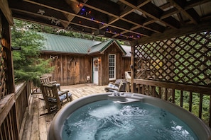 Modern hot tub just a few feet from the front door with gazebo overhead