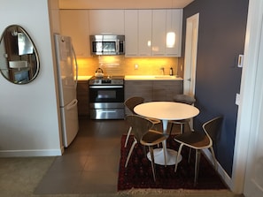 Sleek kitchen with marble counter tops, authentic Knoll table and heated floors