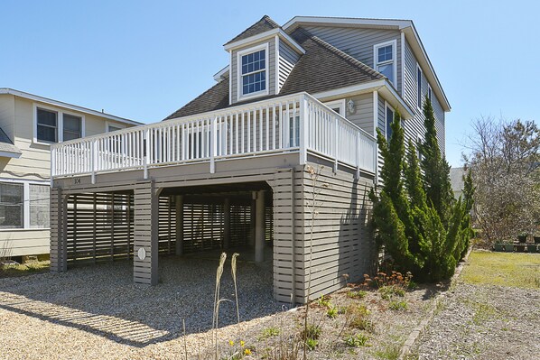 Front of house with lots of parking and dormant perennial garden
