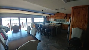 View of open kitchen and dining area looking out to lake.
