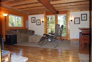 Open living/dining area with queen sleeper sofa and french doors to large deck