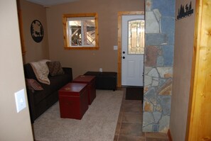 Cozy cabin entry with queen sleeper sofa and laundry room