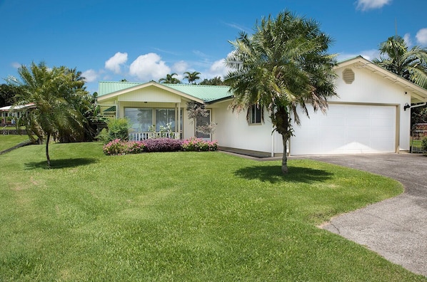 Beautiful tropical bungalow with manicured fenced lawn and a 2 car garage. 
