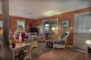 Living area overlooks pond and open to enclosed porch
