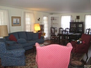 Traditional Cape living room with 2 sofas, 3 armchairs, and dining room table