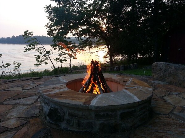 Enjoy seating on the lakeside native stone patio and fire pit area