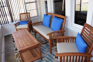 Enclosed front porch with patio set.