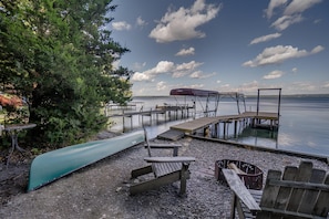 Waterfront area with firepit and canoe available for guests to use