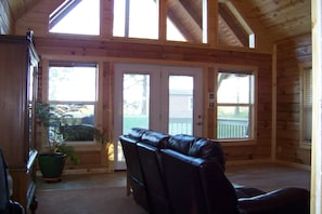 living room with window wall, looking out to the front porch