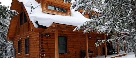 Newly constructed log home with covered front porch and rockers