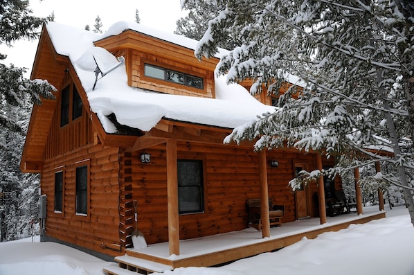 Newly constructed log home with covered front porch and rockers