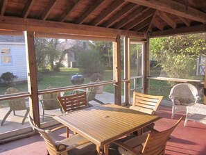 Large screened porch with ceiling fan allows outdoor dining and relaxing.