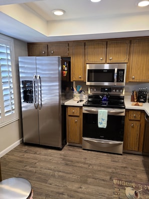 Beautiful kitchen with white shutters, new appliances, and fully equipped.