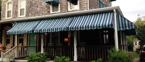 Front view looking at the condo and porch on ground floor w/ awnings