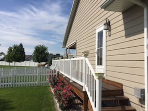 Side of home.  Picket fence surrounds the back yard