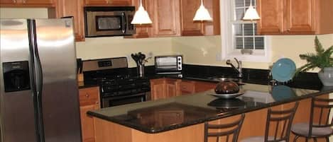 Beautiful modern kitchen with huge island and stainless steel appliances.