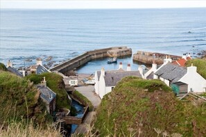 A view of Pennan from the clifftop road.The Harbour House is in centre of image.