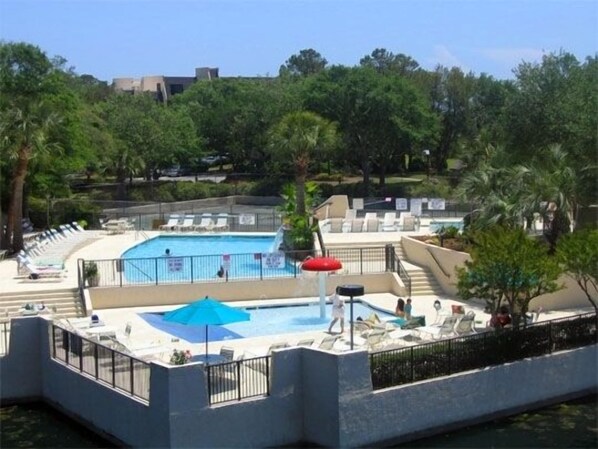 beautiful tropical pool area with tanning shelf. adult/child pools, hot tub.