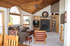 Upstairs vaulted living room with comfortable couch and two chairs.