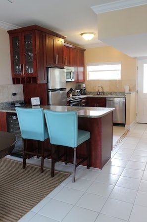 Stylish bar stools conveniently located next to the wine fridge