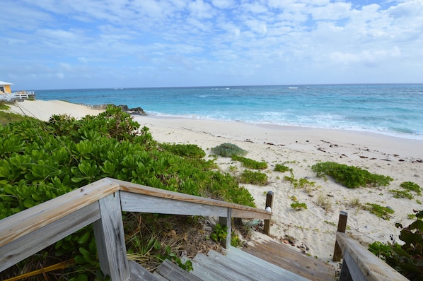 Steps directly from large deck to secluded pristine white sandy beach.