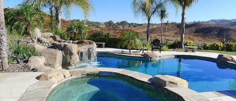 Spa, waterfall and pool with hills and vineyards in distance