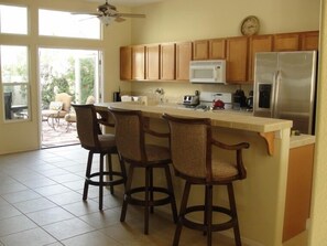 Kitchen with Stainless Steel Fridge, and Bar Counter with 3 Swivel Bar Stools