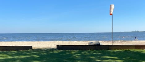 view from deck.  lawn leading to private beach