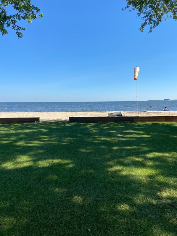 view from deck.  lawn leading to private beach