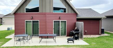 Back of Cabin with outdoor seating, a grill, fire pit and yard.