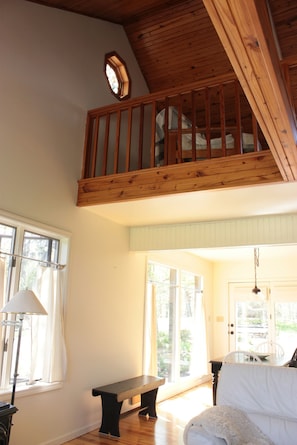 View of wood ceilings, large windows and cozy loft upstairs.
