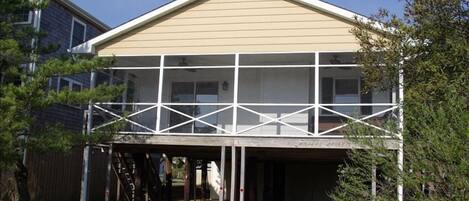 Large screened in porch with seating and dining areas. Table seats 6-8.