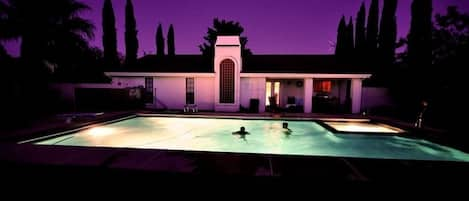 Guests enjoying the pool at night.